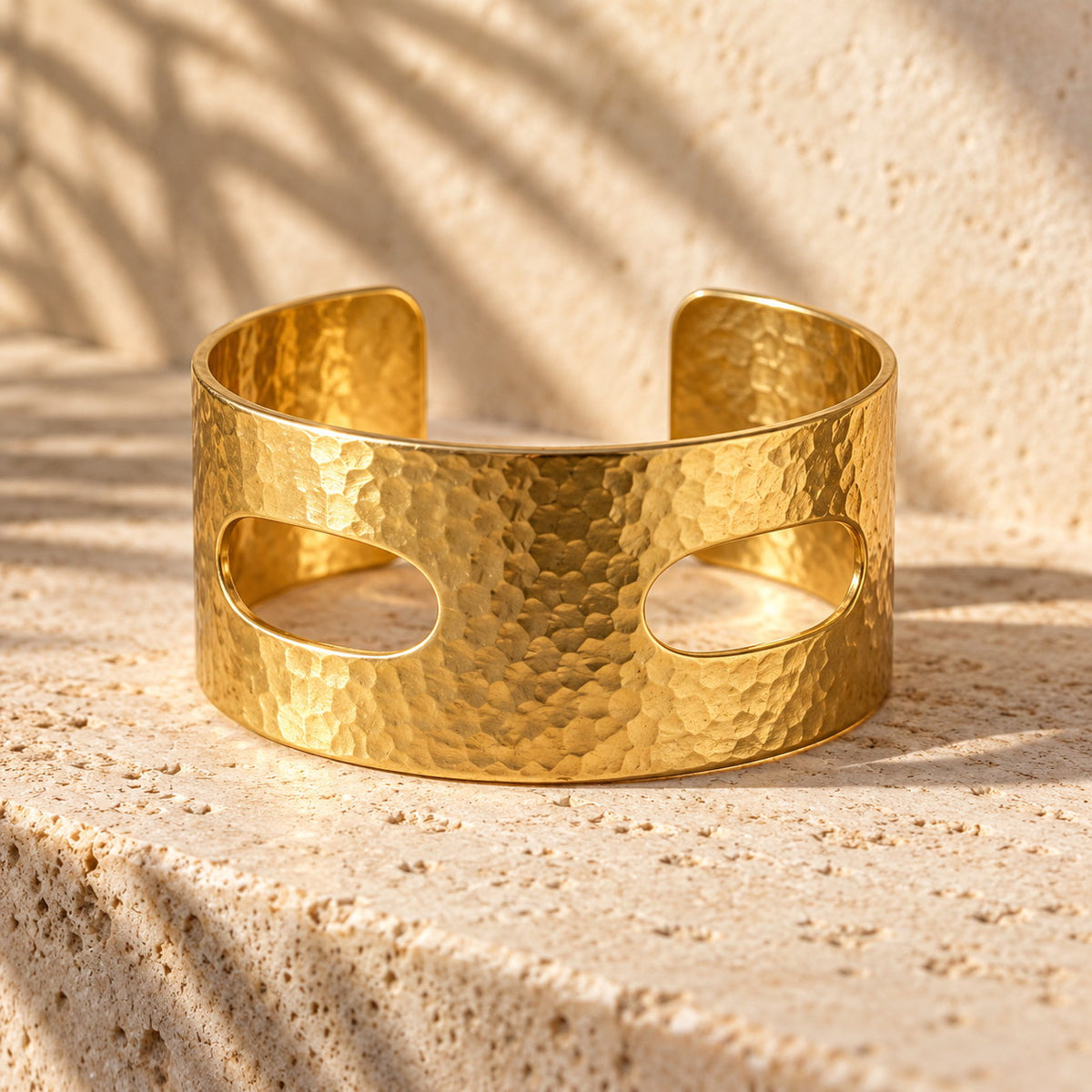 Thread Count 36 mm hand-hammered gold cuff on travertine, two oval scarf slots through the face