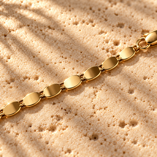 Bar None Gold Cobra Chain macro close-up: flat polished oval gold plates linked toward the lobster clasp
