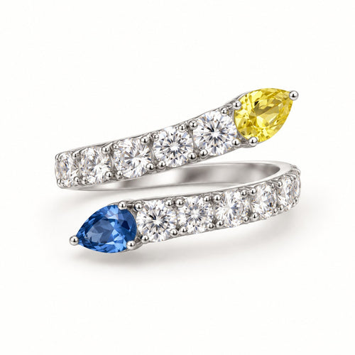 Opposites Attract bypass ring with yellow and blue pear-cut stones and pave band