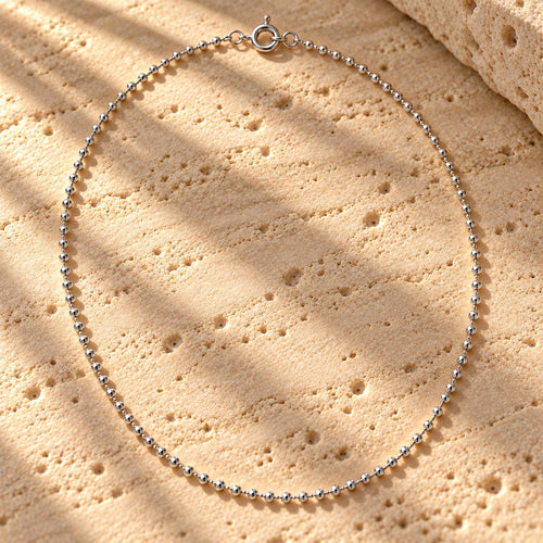 Bar None bead chain in sterling silver laid on travertine, polished beads and spring-ring clasp