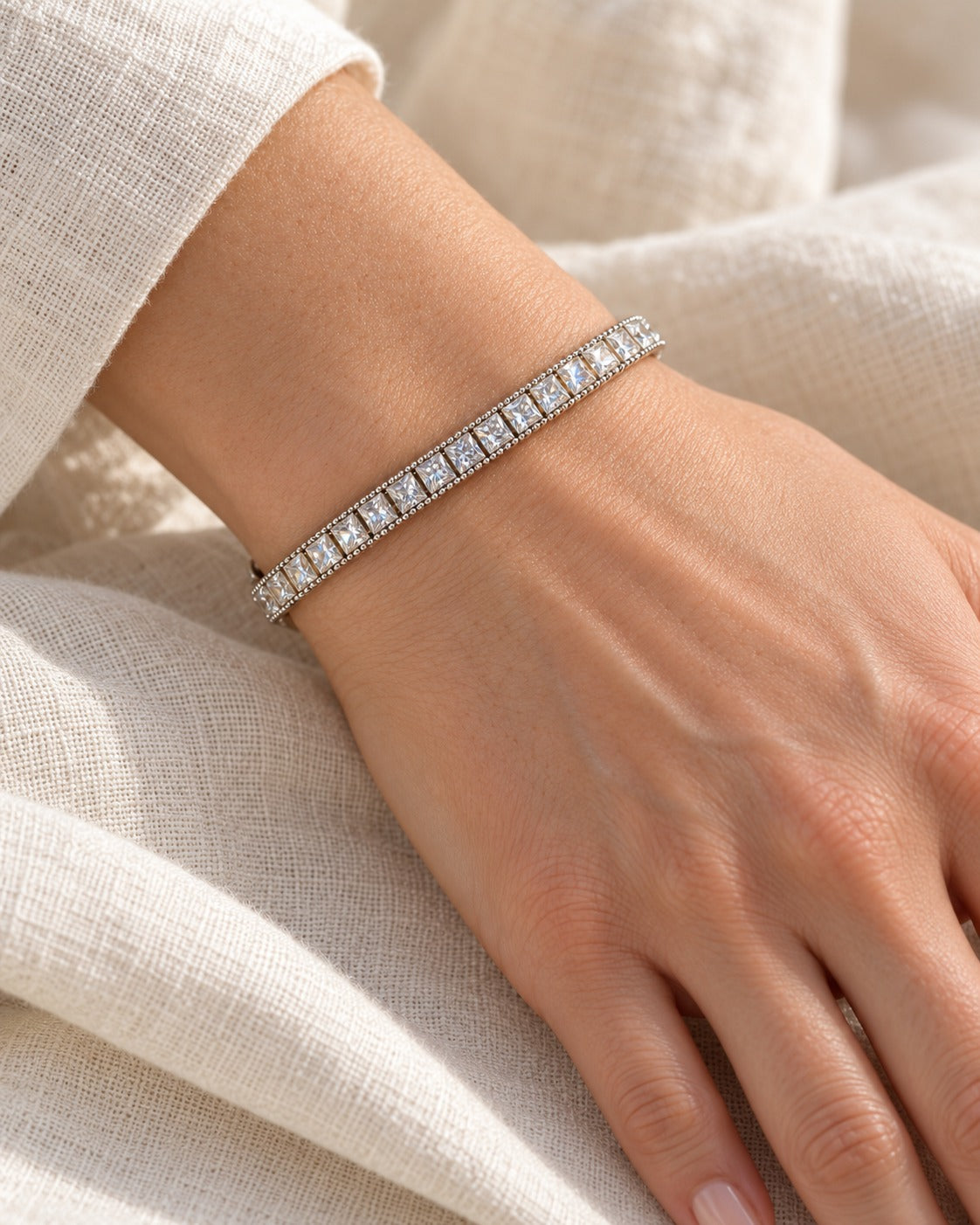 Fair and Square tennis bracelet on the wrist — square princess-cut stones with a beaded edge