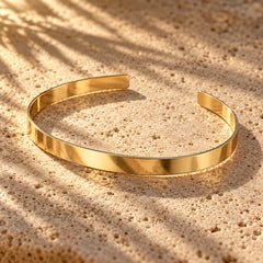Power Couple: the thin flat open gold cuff on sunlit stone