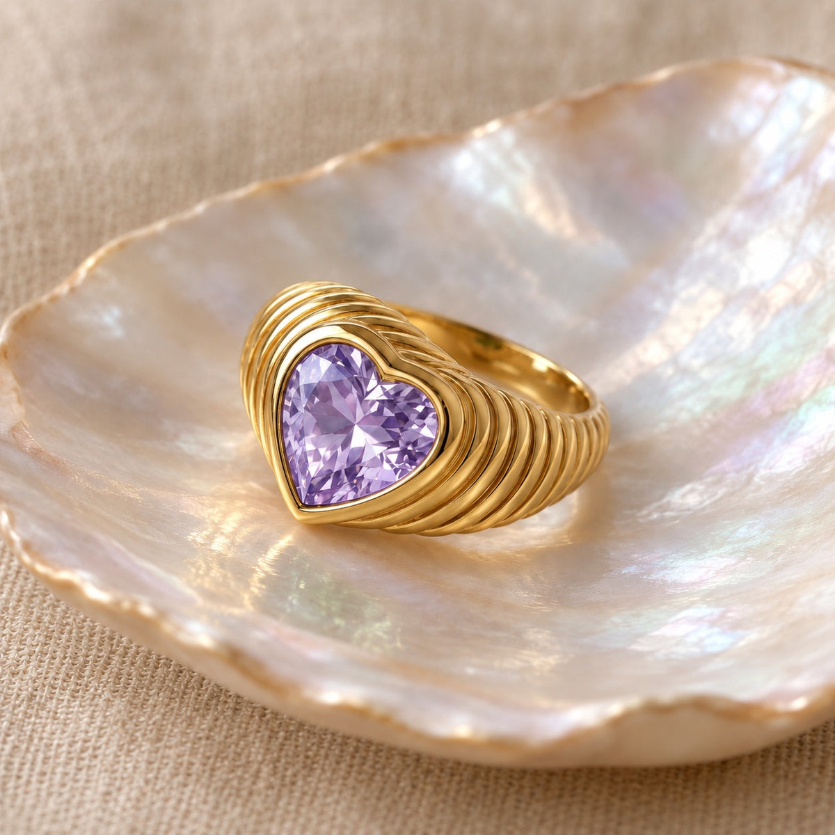 Sealed With a Heart ribbed gold ring with Light Purple heart stone on a shell dish (BU-RG-013-LP)